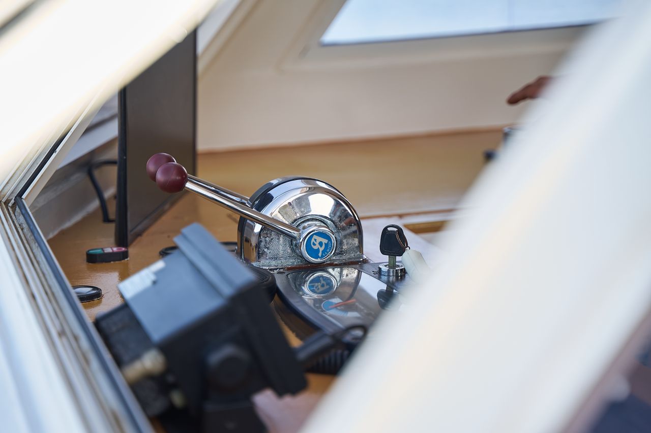 our-story-02 Detailed view of boat control levers with shiny metal finish and window reflections.