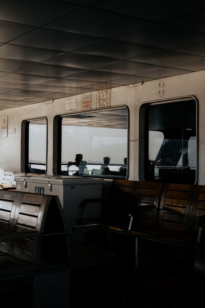 collection-02 Inside view of an Istanbul ferry with wooden seating and passengers.